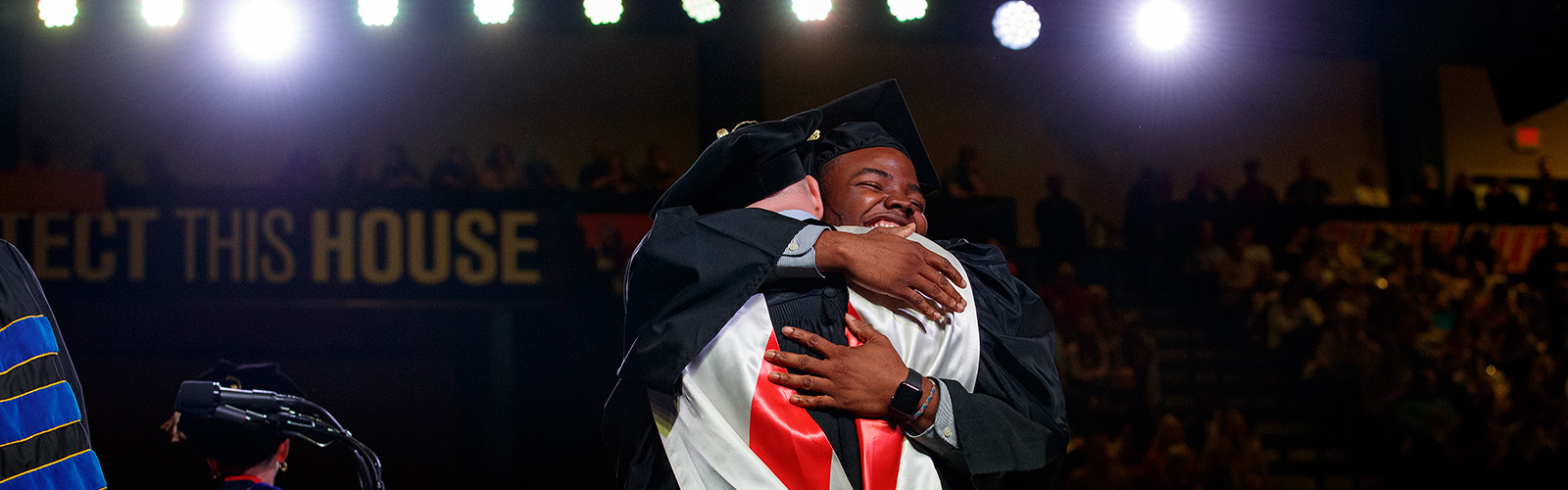 A UT Martin graduate embraces Chancellor Keith Carver at a commencement ceremony